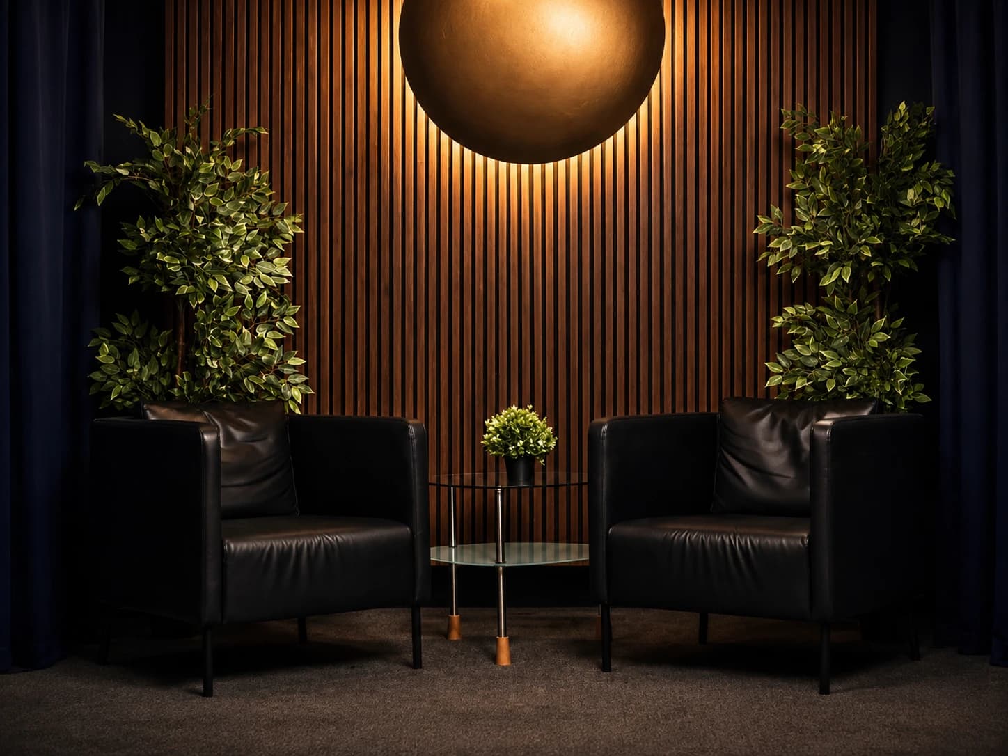 Two black leather chairs with a small glass table between them in The Wing.