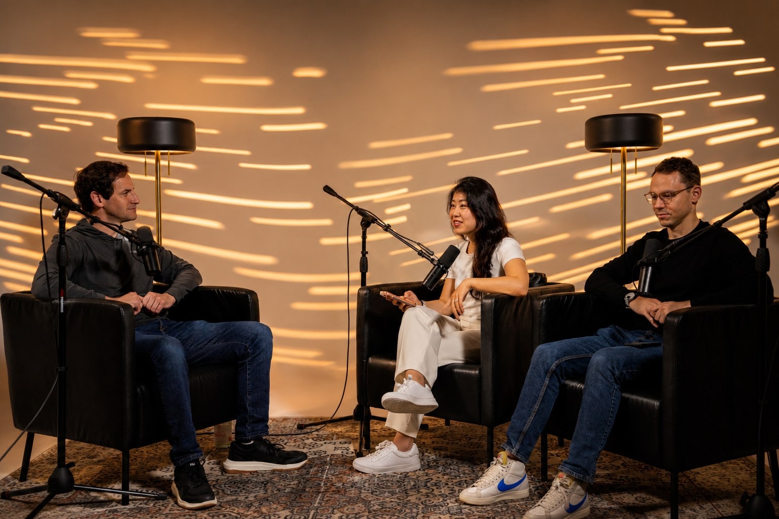 Three guests recording a podcast in a warm VibeShack studio set