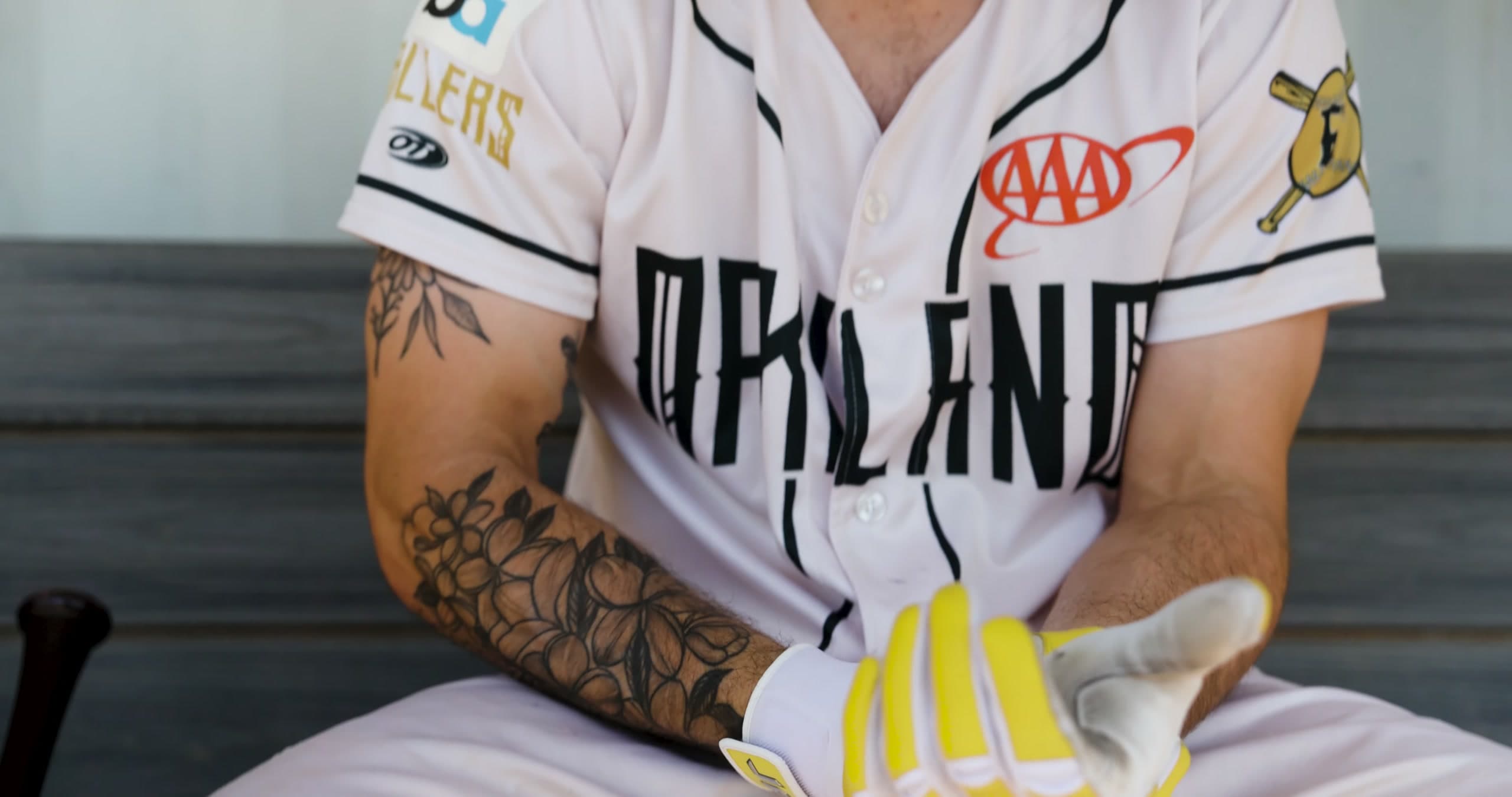 Damian Stone pulls on his batting gloves in the dugout